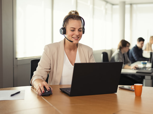 Frau mit Headset an rundem Tisch
